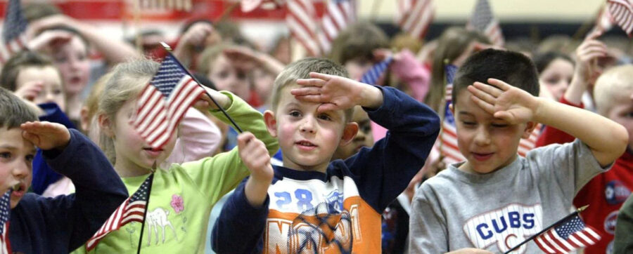 Cute, patriotic schoolchildren waving American flags